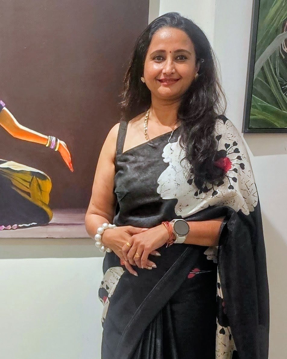 Artist Reshma Venkatraman beside her paintings